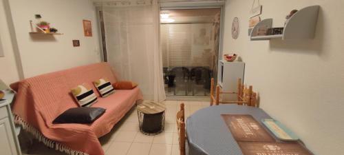 a small living room with a couch and a table at joli studio cabine 4 personnes à 300 m de la plage in Argelès-sur-Mer