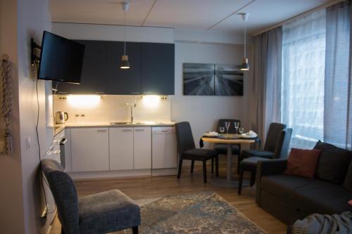 ヘルシンキにあるAurinkolahti cosy apartment with warm parkingのリビングルーム(ソファ付)、キッチン(テーブル付)