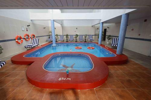 a large swimming pool in a large room at City Tower Hotel in Fujairah