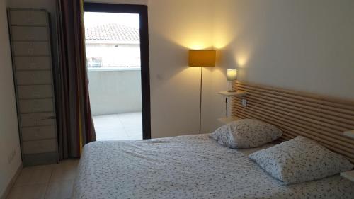a bedroom with a bed with two pillows and a window at Appartement B16 onde Marine in Port-Vendres