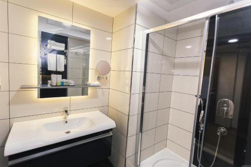 a white bathroom with a sink and a shower at Fesa Business Hotel in Gebze