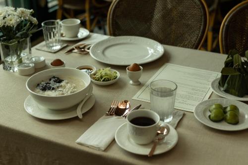 a table with plates of food and a cup of coffee at Hotel Verdigris in Phuket Town