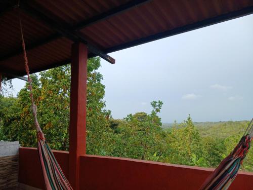 two hammocks hanging from a porch with a view at Hotel Cabañas Casita La Ermita in San Carlos