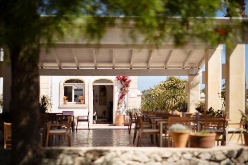a patio with tables and chairs and a building at Borgo Mulino a Vento - Resort in Uggiano la Chiesa