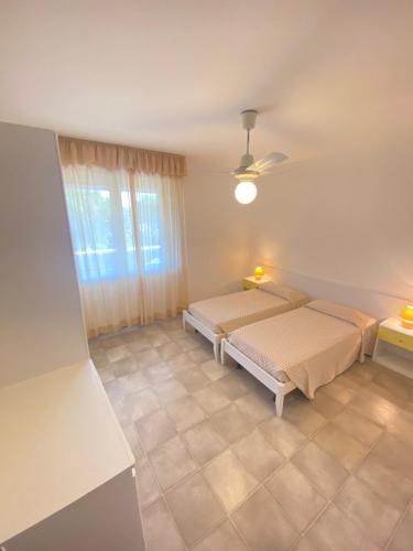1 dormitorio con 2 camas y ventana en Residence Luna, en Lignano Sabbiadoro
