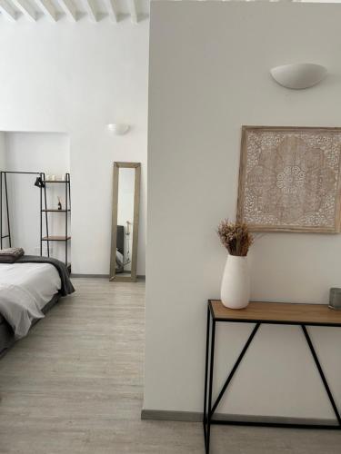 een slaapkamer met een bed en een vaas op een tafel bij Splendido Loft Centro Storico Parma in Parma