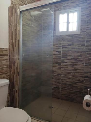 a glass shower in a bathroom with a toilet at Hotel Cabañas Casita La Ermita in San Carlos