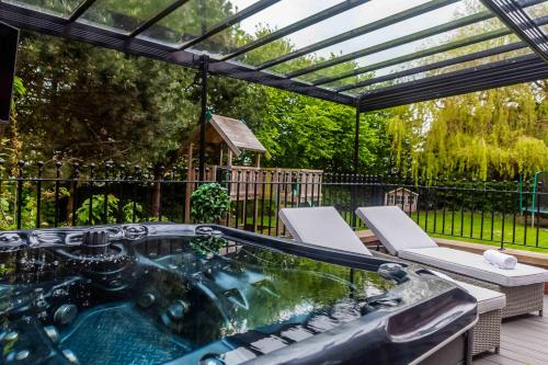 a hot tub on a deck with a pergola at Guest Homes - The Grove in Hartlepool