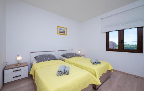 Duas camas num quarto com lençóis amarelos em Gorgeous Apartment In Pula With Kitchen em Muntić