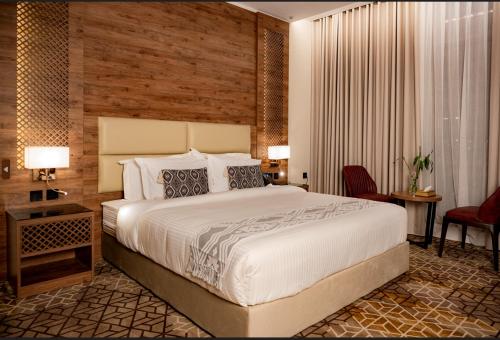 1 dormitorio con 1 cama blanca grande y escritorio en فندق ايليت الهجرة en Medina