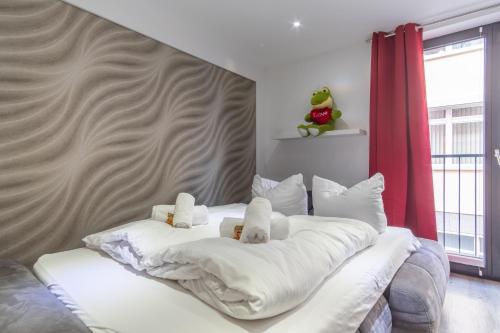 a bedroom with a white bed with white pillows at Arbeitsplatz, Tiefgaragenstellplatz, 4k TV Netflix in Leipzig