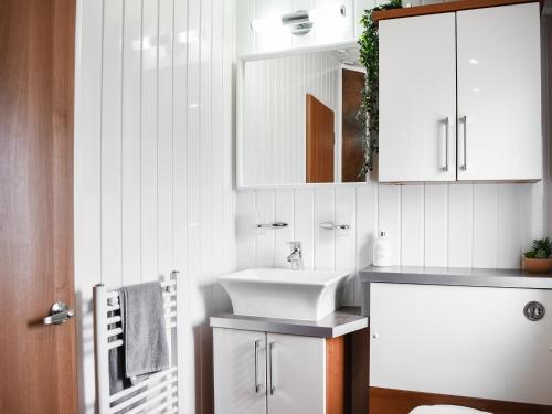 a bathroom with a sink and a mirror at Solway Escape in Plumbland
