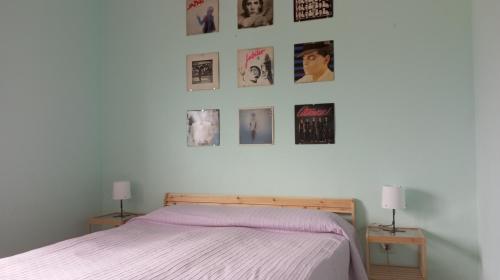 1 dormitorio con 1 cama y cuadros en la pared en B&B il riccio, en Paspardo
