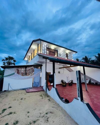 a house with a balcony on the beach at Greens Villa in Kattankudi