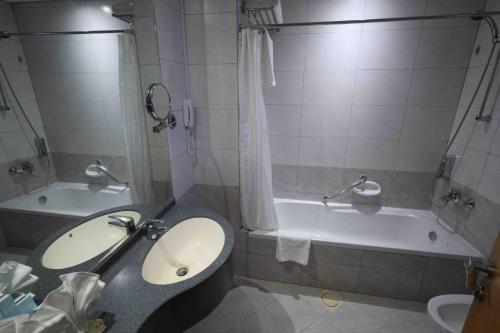 a bathroom with a sink and a tub and a toilet at City Tower Hotel in Fujairah