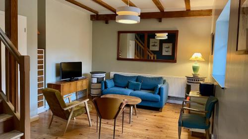 Hôtel du DOMAINE SAINT LOUP : غرفة معيشة مع أريكة زرقاء وطاولة
