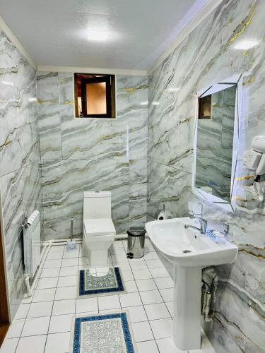 La salle de bains est pourvue d'un lavabo et de toilettes. dans l'établissement SHUKRONA Hotel, à Samarcande