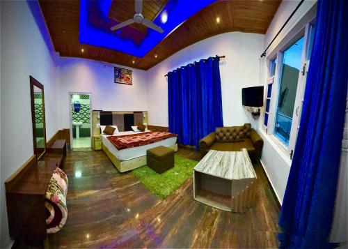 een woonkamer met een bed en een bank bij Himalayan Canvas in Khajjiar 