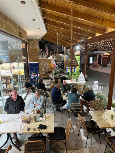 a group of people sitting at tables in a restaurant at Costas Inn in Spílion