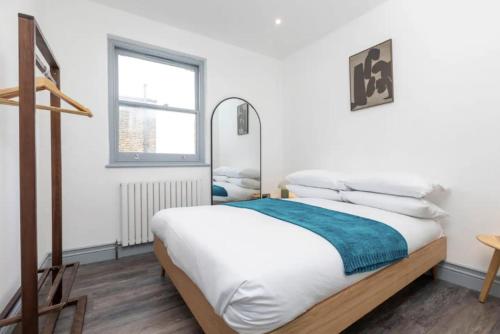 een slaapkamer met een bed en een raam bij Urban Chic: Stylish 1-Bed in the Heart of the City in Londen