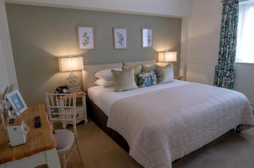 a bedroom with a large white bed with pillows at Leeds Castle Stable Courtyard Bed and Breakfast in Maidstone