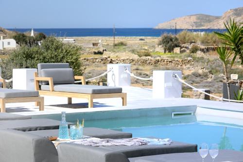 a swimming pool with two chairs and a table and chairsitures at Mykonos Dream Villas in Elia