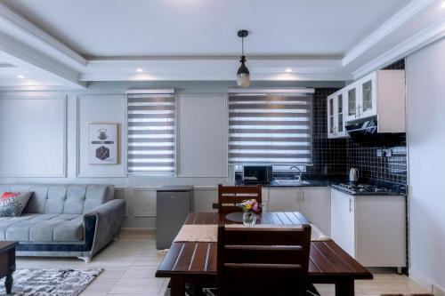 a kitchen and living room with a table and a couch at Lavermo Hotel Apartments in Kampala