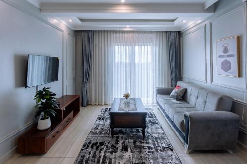 a living room with a couch and a tv at Lavermo Hotel Apartments in Kampala