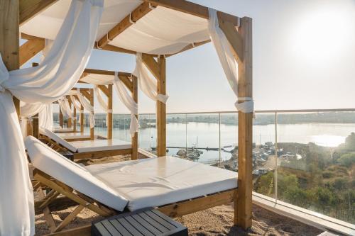 a room with a bed and a view of the water at Jupiter Marina Hotel - Couples & Spa in Portimão