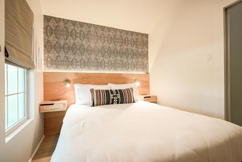 a bedroom with a white bed and a window at Melrose River Club Resort in San Marcos
