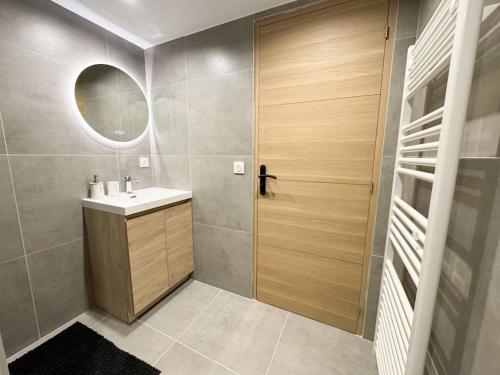 a bathroom with a sink and a wooden door at Allée Royale in Annecy