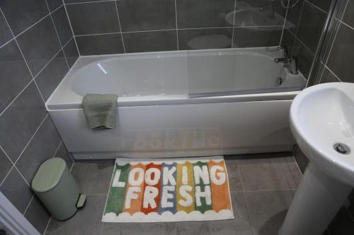 un bagno con vasca e un cartello con scritto "Sembra fresco" di Brand New Luxury Ground Floor 2 Bedroom Apartment free WiFi & Parking a Sheffield