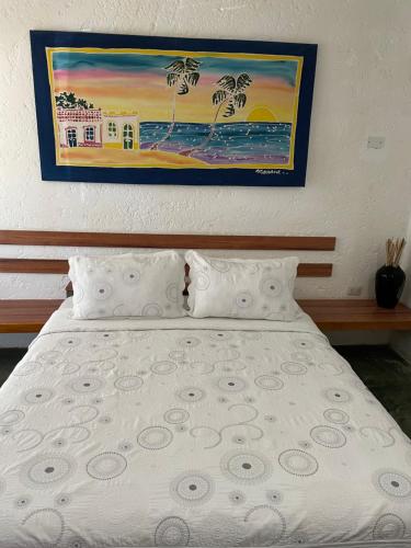 Hotel The Winds Of Margarita في El Yaque: غرفة نوم بسرير مع لوحة على الحائط