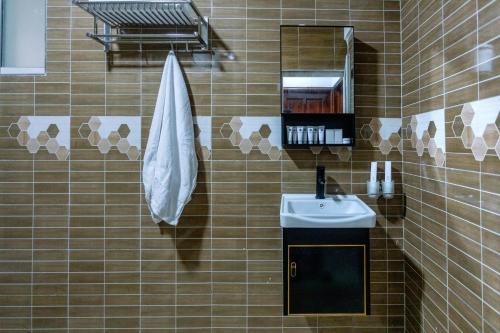 a tiled bathroom with a sink and a mirror at Lavermo Hotel Apartments in Kampala