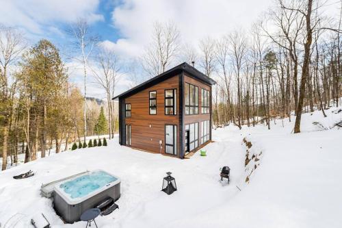 a tiny house in the snow with a tub at Les aurores in Harrington