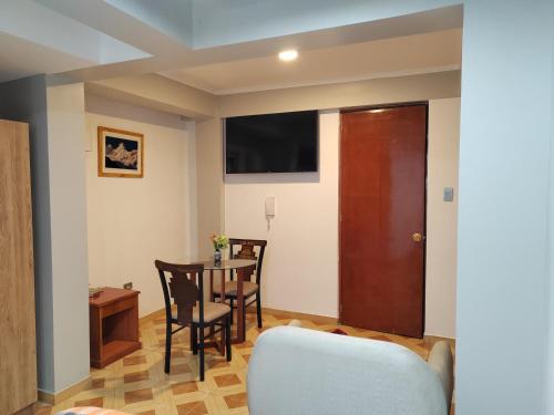 salon ze stołem, krzesłami i drzwiami w obiekcie Hotel Los Inkas w mieście Huaraz