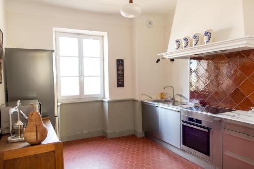 une cuisine avec un évier, une cuisinière et une fenêtre dans l'établissement Superbe maison T3 vue mer & jardin, à Hyères