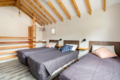 a room with three beds and a staircase at Don Filoteo in Villa La Angostura