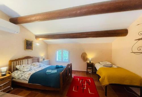 - une chambre avec 2 lits et un tapis rouge dans l'établissement Villa Ylang - climatisée, à Cruis