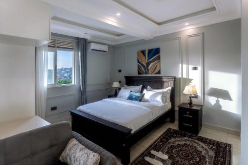 um quarto com uma cama e um sofá em Lavermo Hotel Apartments em Kampala