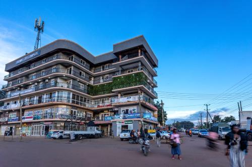 a tall building with people walking in front of it at Lavermo Hotel Apartments in Kampala