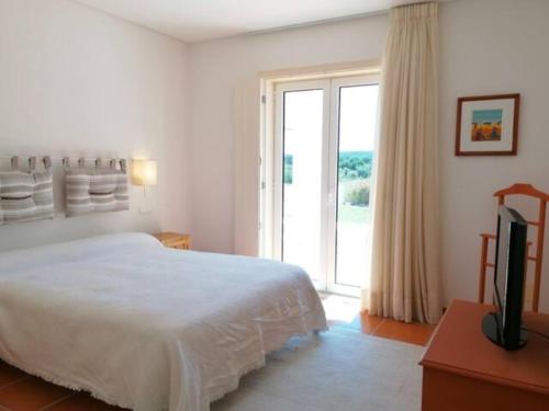 奧比多斯的住宿－VILLA MARTIN，一间卧室设有一张床和一个滑动玻璃门