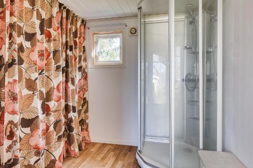 um chuveiro na casa de banho com uma cortina de chuveiro em Cozy holiday accommodation in Skebobruk, Norrtalje em Skebobruk