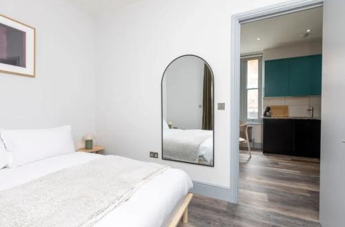 a bedroom with a large white bed and a mirror at Stylish Apt - Newly refurbished - Private Terrace in London