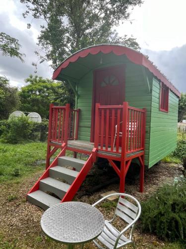a green and red house with a table and a table sidx sidx sidxktopktop at Une bouteille au canal in Dieupentale