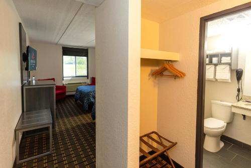 a hotel room with a bathroom and a room with a fireplace at Coratel Inn & Suites by Jasper Mankato in Mankato
