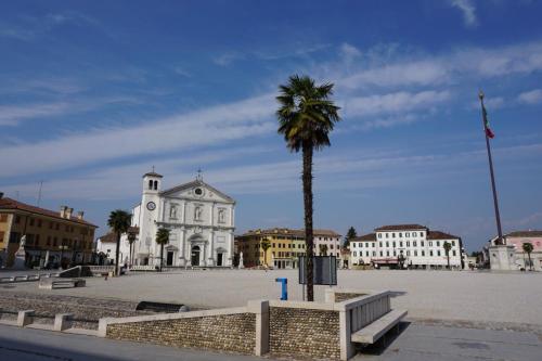 a palm tree in front of a white building at Zi Bitta - guest house in Palmanova
