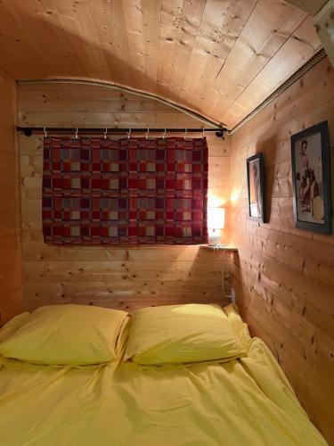 a bed in a wooden room with a window at Une bouteille au canal in Dieupentale