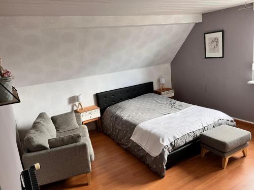 une chambre avec un lit, une chaise et un canapé dans l'établissement JM et Domi, à Hœrdt