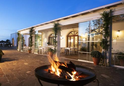 a fire pit in a courtyard in front of a building at Borgo Mulino a Vento - Resort in Uggiano la Chiesa